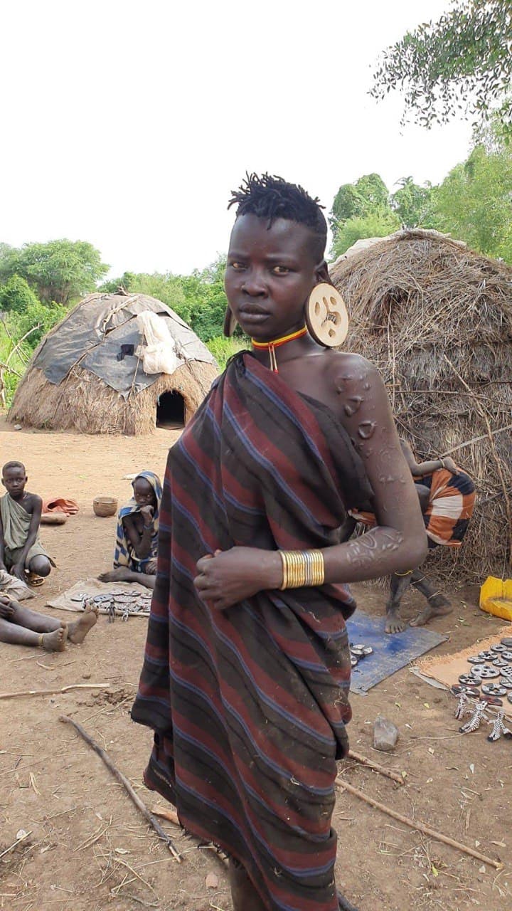 Mursi woman with ear plate adornment in the Omo Valley, Ethiopia