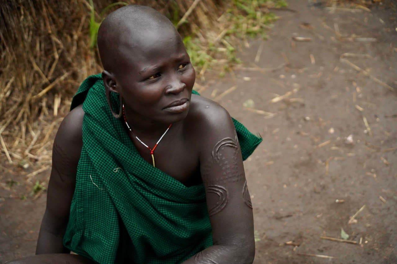 Sitting portrait with traditional scarification in the Omo Valley, Ethiopia